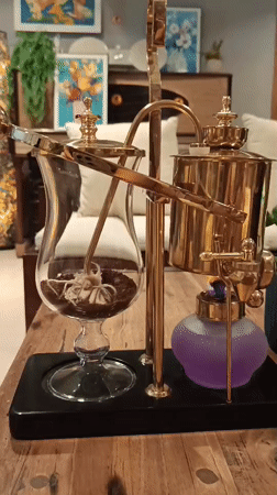Brass coffee siphon brewing from flame to cup