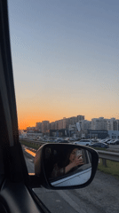 Driver captured in side mirror during sunset in Krasnodar