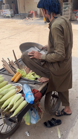 Street corn vendor serves morning customers in Multan Pakistan