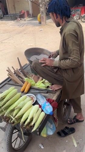 Street corn vendor serves morning customers in Multan Pakistan