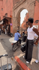 Busy morning in Marrakesh's medina, luggage, locals, and a sleeping cat