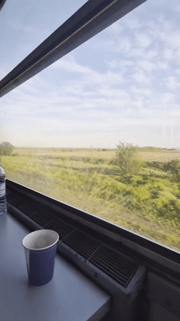 Train passenger captures countryside view near Bulgarian village