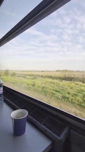 Train passenger captures countryside view near Bulgarian village