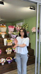 Woman creates content in flower shop during midday visit
