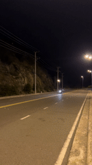 Night motorcycle riders spotted on cliff road in Vietnam