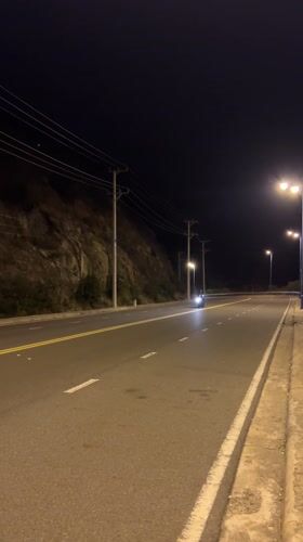 Night motorcycle riders spotted on cliff road in Vietnam