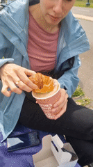 Woman enjoys outdoor breakfast with croissant and coffee