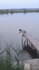 Jumping off a wooden pier into a calm Moldova lake