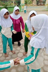 Young women gather for activities amid flowering plants in Keudekrueng
