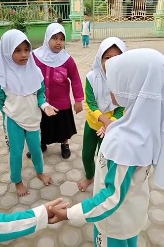 Young women gather for activities amid flowering plants in Keudekrueng