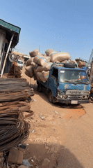 Overloaded Toyota truck struggles through dirt road in Nigeria