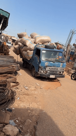 Overloaded Toyota truck struggles through dirt road in Nigeria