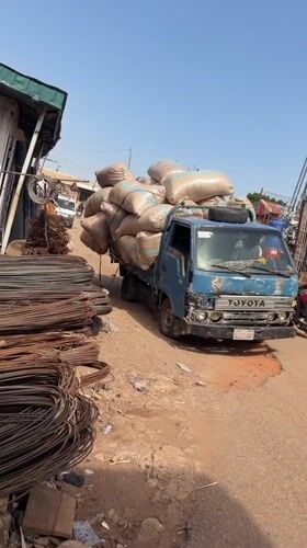 Overloaded Toyota truck struggles through dirt road in Nigeria