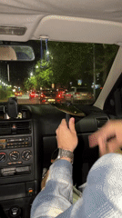 Passenger holds cymbal in moving car on wet Plovdiv street