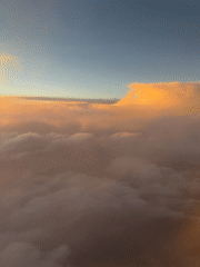 Aircraft passenger captures golden-lit clouds over Coaxusco, Mexico