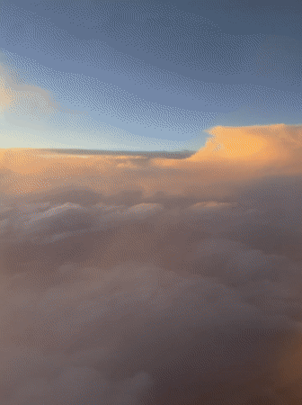 Aircraft passenger captures golden-lit clouds over Coaxusco, Mexico