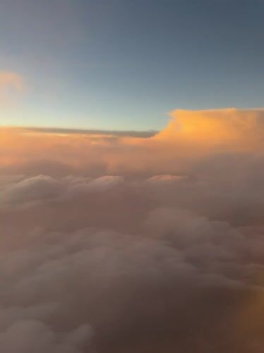 Aircraft passenger captures golden-lit clouds over Coaxusco, Mexico