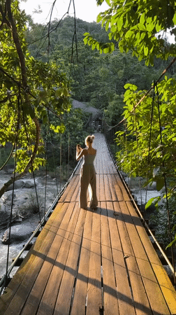 Suspension bridge and river play in forested Ranong