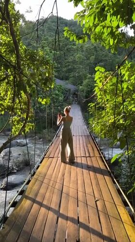 Suspension bridge and river play in forested Ranong