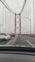 Driver crosses red-towered suspension bridge in Lisbon