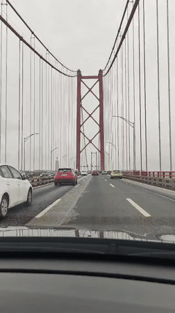 Driver crosses red-towered suspension bridge in Lisbon