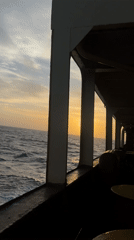 Sunset observed from ship deck over ocean waters