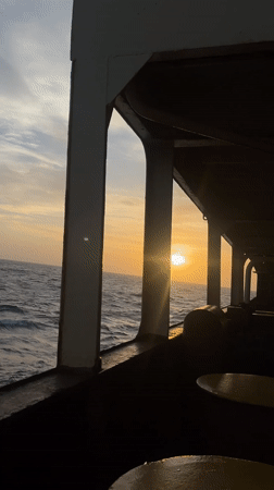Sunset observed from ship deck over ocean waters