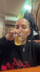 Woman drinks golden beverage at Moscow restaurant