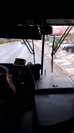 Bus driver navigates Cuiabá streets on cloudy evening