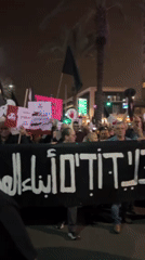 Nighttime protest in Tel Aviv draws crowds with multilingual signs