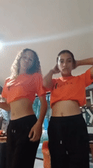 Two women dance in matching outfits in Playa El Agua