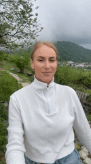 Woman records selfie video amid overcast Sochi hillside scenery