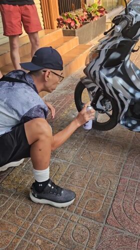 Person customizes motorcycle with zebra stripes in Nha Trang