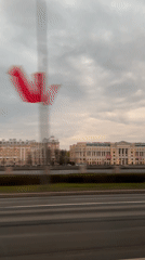 Vehicle passenger films Saint Petersburg cityscape with red object