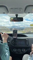 Driver approaches Montenegro town with mountains visible ahead