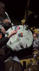 Card games and waterside hangout at dusk in Сарс