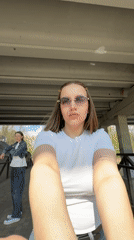 Woman takes selfie by waterfall under bridge in Klin