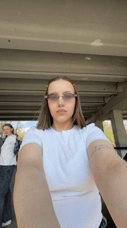 Woman takes selfie by waterfall under bridge in Klin