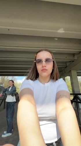 Woman takes selfie by waterfall under bridge in Klin