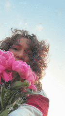 Person enjoys pink peonies in Noviy, Russia