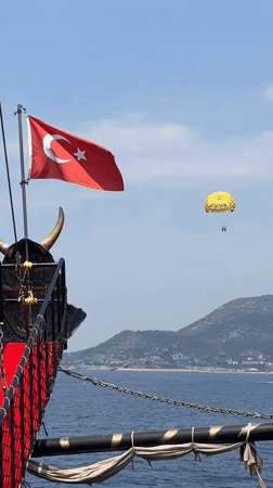 Parasailing and a flagged ship off the Alanya coast