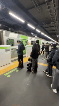 Morning commuters wait on train platform in Tokyo