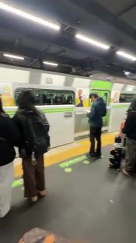 Morning commuters wait on train platform in Tokyo