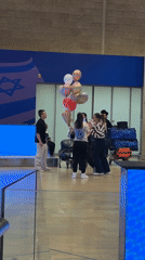 Woman receives warm welcome at Israeli airport with flowers, balloons