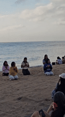 Kuta Beach at golden hour — people, vendors, and ocean views