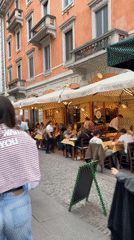 Milan street bustles with pedestrians and outdoor diners