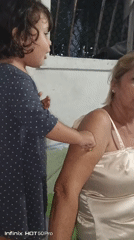 Child and woman interact indoors in Caracas