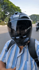 Motorcyclist observed on tree-lined street in Dhaka