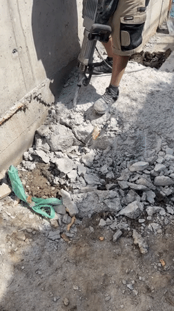 Construction worker jackhammers concrete in Plovdiv, Bulgaria