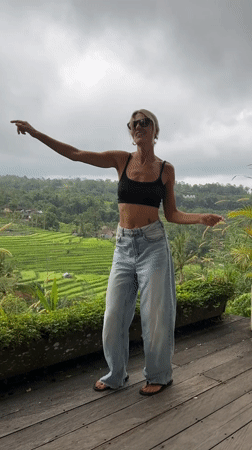Women dance and pose on deck overlooking Penebel rice paddies